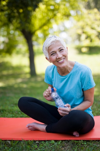 Portrait of smiling senior woman relaxing after exercising