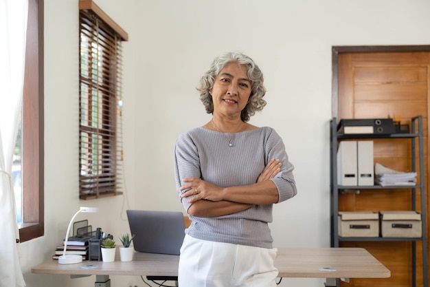 Portrait of smiling senior woman standing posing in home happy confident middleaged female look at camera show confidence and success