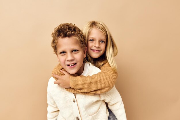 Portrait of smiling sibling against beige background