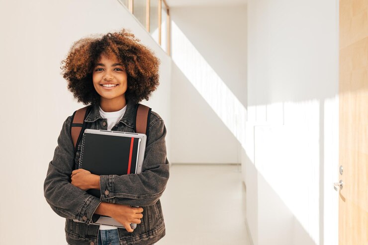 Photo portrait of smiling student with book in school