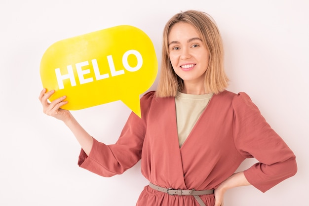 Ritratto di donna loquace sorridente che tiene tag ciao, lei comunica su internet