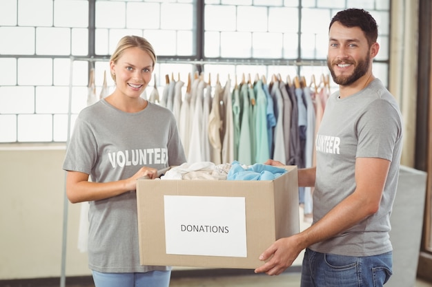 Портрет улыбающегося добровольца, проведение одежды пожертвования поле