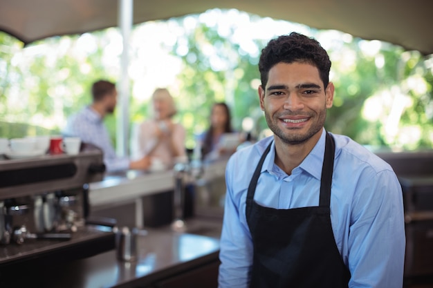 Portrait of smiling waiter at counter