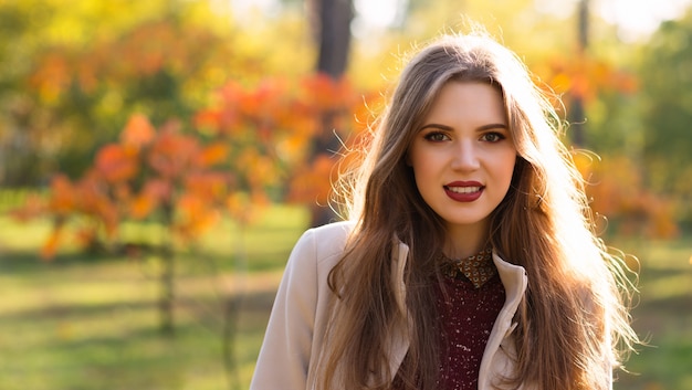 Ritratto della donna sorridente nel parco di autunno