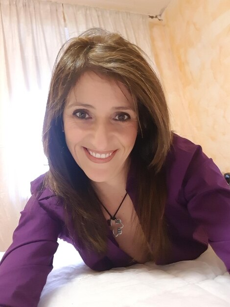 Photo portrait of smiling woman on bed at home