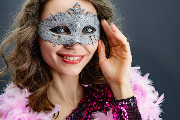Портрет улыбающейся женщины в карнавальных масках смотрит в камеру крупным планом
