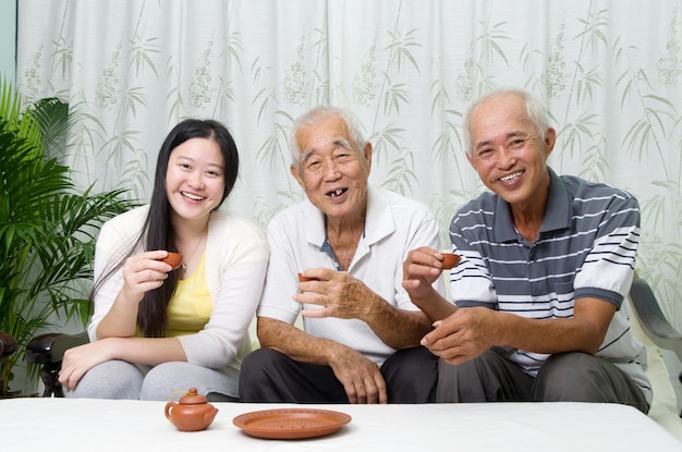 Photo portrait of smiling woman enjoying tea with men at home