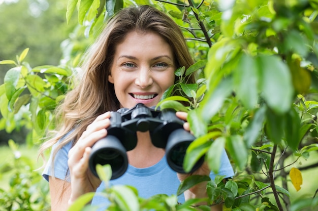 Portrait of smiling woman holding binocular 