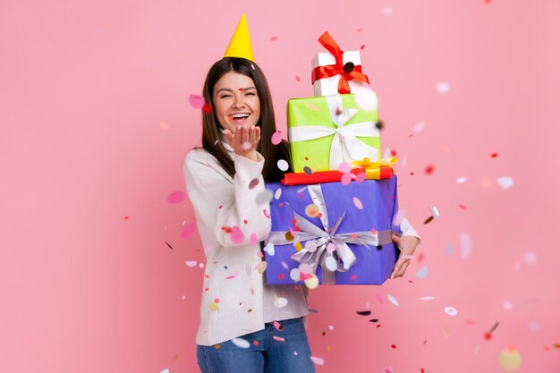 Photo portrait of smiling woman holding gift against yellow background