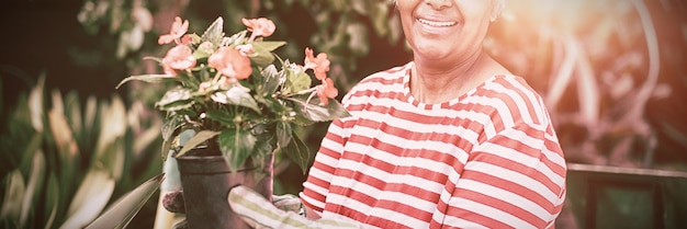 Photo portrait of smiling woman holding potted plant