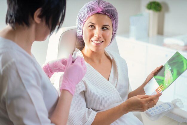 Foto ritratto di una donna sorridente che tiene in mano uno smartphone