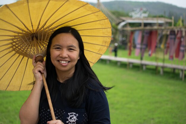 Portrait of smiling woman holding umbrella