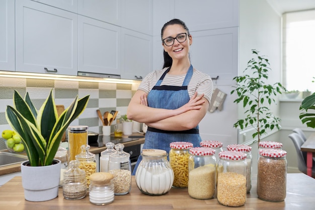 Ritratto di donna casalinga sorridente in un grembiule in cucina