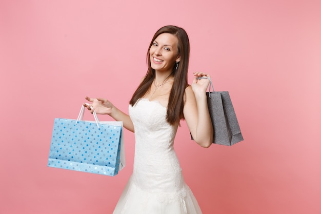 Portrait of smiling woman in lace white dress holding multi colored packages bags with purchases after shopping