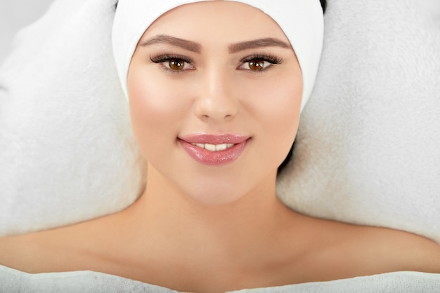 Photo portrait of smiling woman lying on cosmetological coach