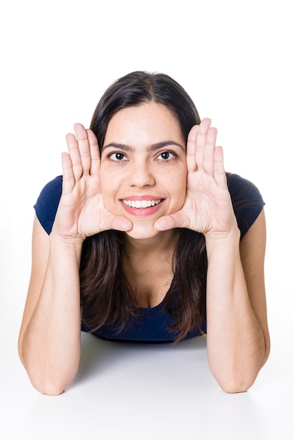 Portrait of smiling woman lying over white background