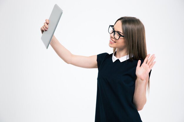 Portrait of a smiling woman making video chat on tablet computer isolated