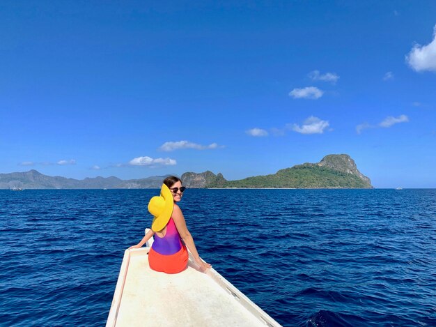 Portrait of smiling woman sailing on boat over blue sea against sky