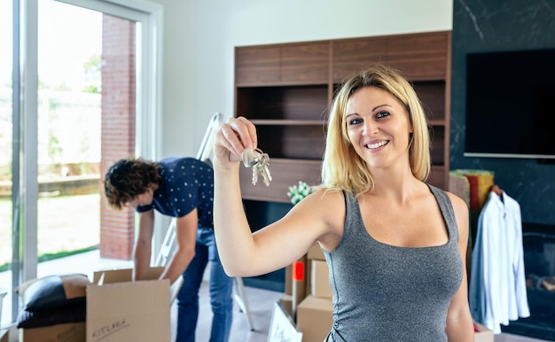 Photo portrait of smiling woman showing keys at home