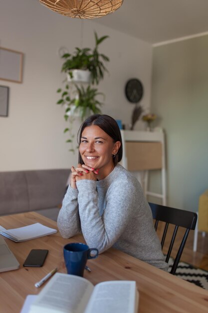 Photo portrait of smiling woman sitting at home