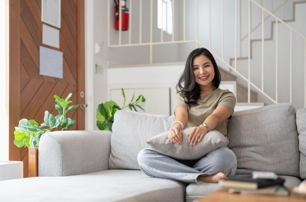 Photo portrait of smiling woman sitting on sofa at home