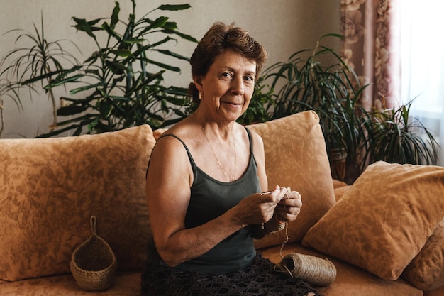portrait of smiling woman sitting on sofa at home