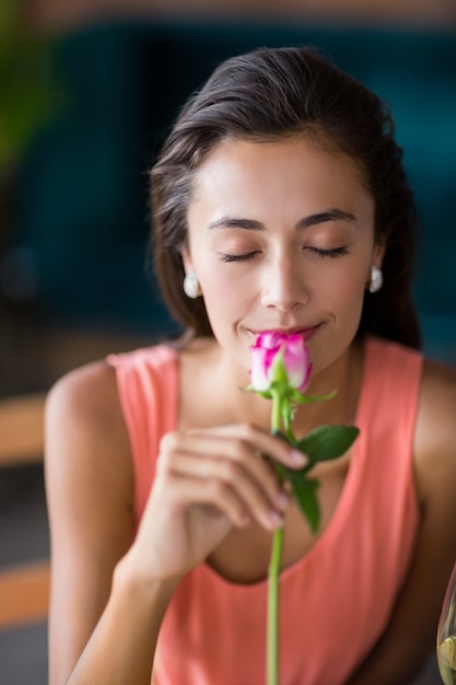 Portrait of smiling woman smelling a rose