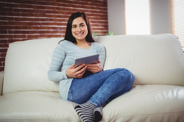 Portrait of smiling woman on sofa at home