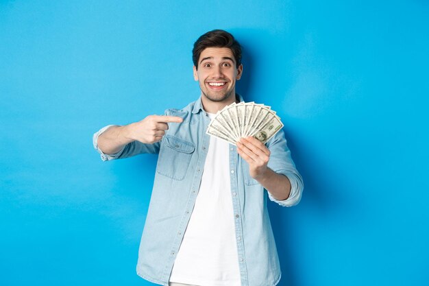 Portrait of smiling woman standing against blue background