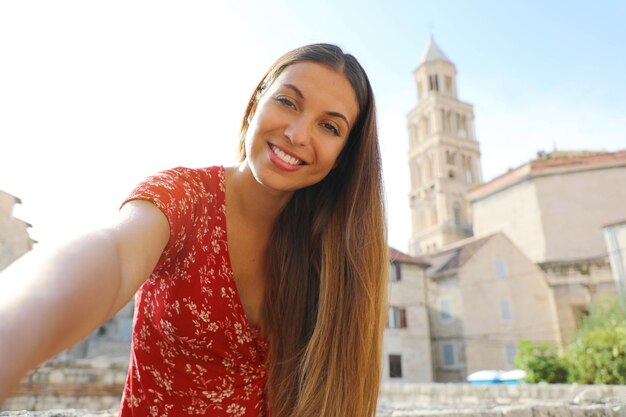 Foto ritratto di una donna sorridente in piedi contro gli edifici della città