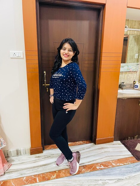 Portrait of smiling woman standing against door