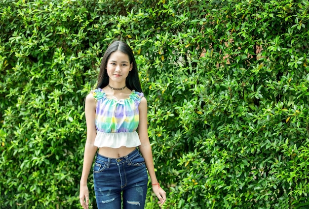 Portrait of a smiling woman standing against plants