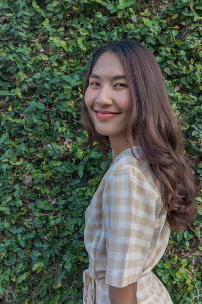 Portrait of smiling woman standing against plants