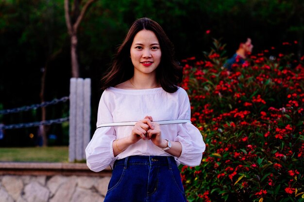 Photo portrait of smiling woman standing against plants