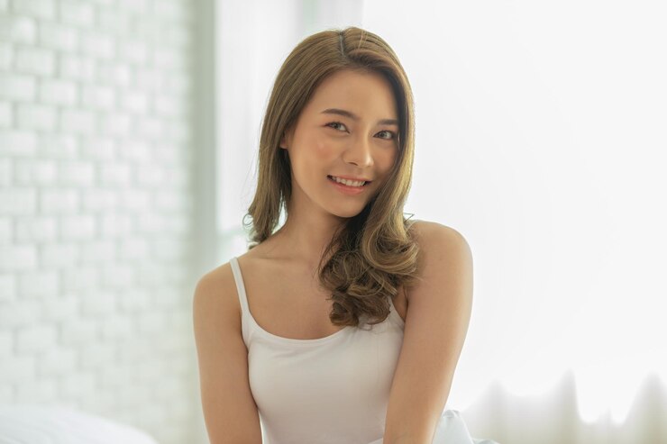 Photo 壁に寄りかかって立っている笑顔の女性の肖像画