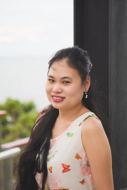 Portrait of smiling woman standing against wall