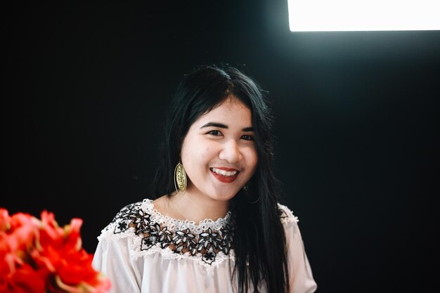 Portrait of smiling woman standing against wall