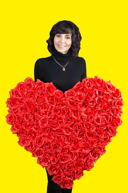 Portrait of smiling woman standing against yellow background