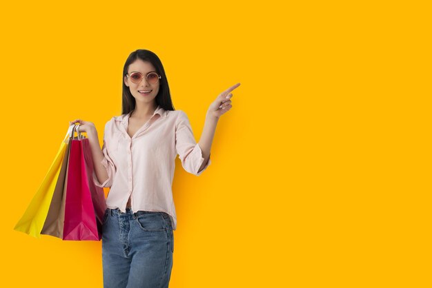 Portrait of smiling woman standing against yellow background