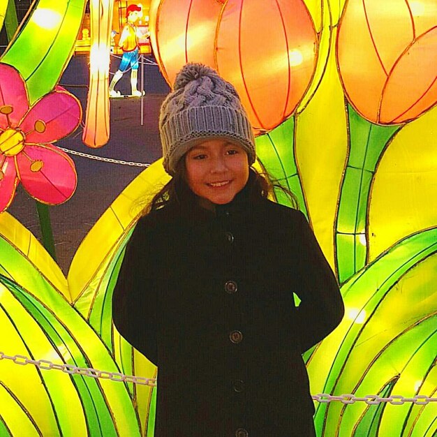 Portrait of smiling woman standing against yellow wall