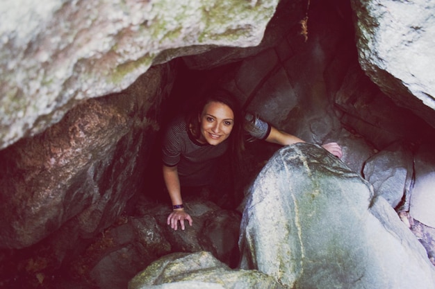 Portrait of smiling woman standing amidst rocks