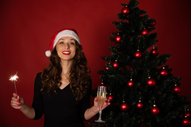 Foto ritratto di una donna sorridente in piedi vicino all'albero di natale