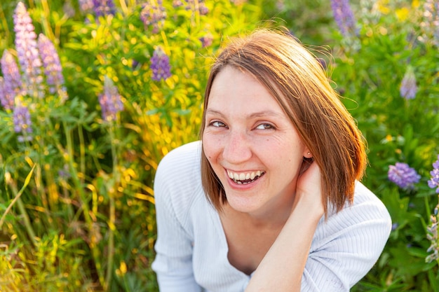 Photo portrait of smiling woman standing by flowering plants