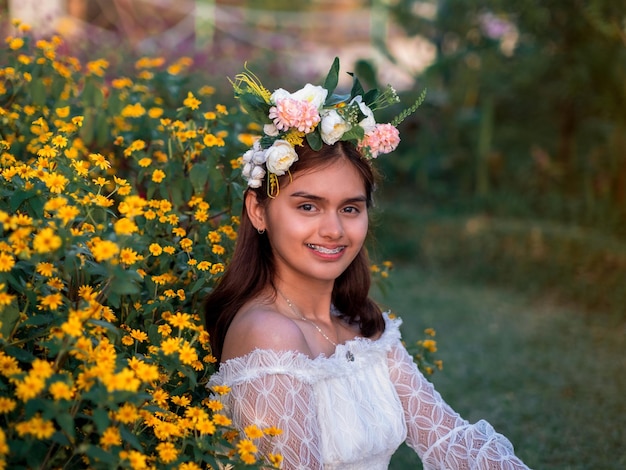 Portrait of smiling woman standing by flowering plants