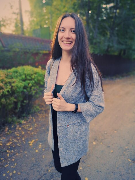 Photo portrait of smiling woman standing on footpath