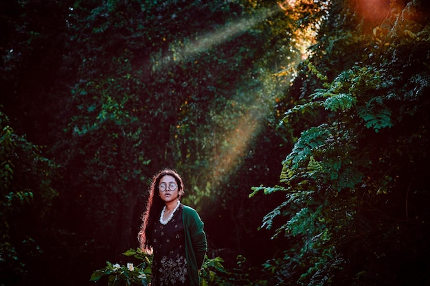 Foto ritratto di una donna sorridente in piedi nella foresta