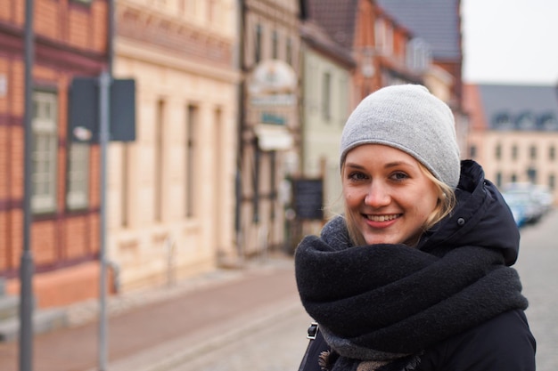 portrait of smiling woman standing on road in city