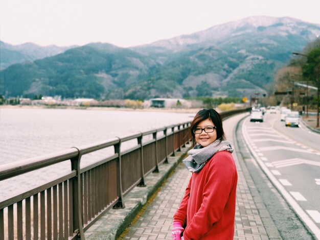 Photo portrait of smiling woman standing on road during winter