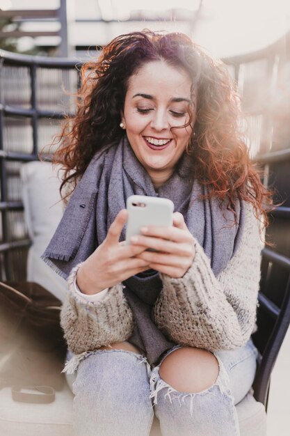 Photo portrait of smiling woman using mobile phone