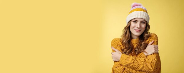 Portrait of smiling woman wearing hat against yellow background